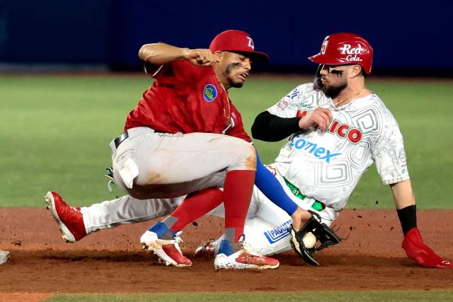Mexico's #31 Julian Rafael Ornelas jumps to second base while Dominican Republic's #02 Gustavo Nunez tries to catch the ball in the eighth inning of the Caribbean Series baseball tournament second game between Dominican Republic's Leones del Escogido and Mexico's Charros de Jalisco at the Panamerican Stadium in Jalisco, Mexico, on February 1, 2026. (Photo by Ulises Ruiz / AFP)