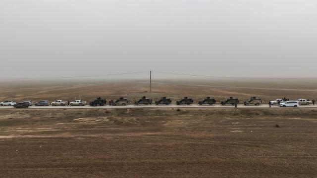 An aerial view shows a Syrian government forces military convoy driving along a road in the countryside near the northeastern Syrian city of Hasakeh on February 2, 2026. Northeast Syria's Hasakeh was under a curfew on February 2, 2026, as government forces were expected to enter parts of the city under an integration deal with the Kurds. Damascus and Kurdish forces reached a comprehensive agreement on Friday to gradually integrate the Kurds' military and civilian institutions into the state, after the minority ceded territory to advancing government forces in recent weeks. (Photo by Bakr ALKASEM / AFP)