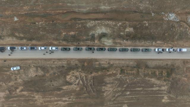 An aerial view shows a Syrian government forces military convoy driving along a road in the countryside near the northeastern Syrian city of Hasakeh on February 2, 2026. Northeast Syria's Hasakeh was under a curfew on February 2, 2026, as government forces were expected to enter parts of the city under an integration deal with the Kurds. Damascus and Kurdish forces reached a comprehensive agreement on Friday to gradually integrate the Kurds' military and civilian institutions into the state, after the minority ceded territory to advancing government forces in recent weeks. (Photo by Bakr ALKASEM / AFP)