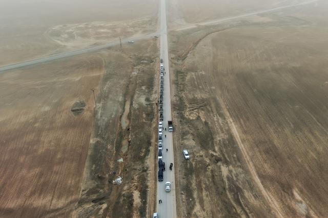An aerial view shows a Syrian government forces military convoy driving along a road in the countryside near the northeastern Syrian city of Hasakeh on February 2, 2026. Northeast Syria's Hasakeh was under a curfew on February 2, 2026, as government forces were expected to enter parts of the city under an integration deal with the Kurds. Damascus and Kurdish forces reached a comprehensive agreement on Friday to gradually integrate the Kurds' military and civilian institutions into the state, after the minority ceded territory to advancing government forces in recent weeks. (Photo by Bakr ALKASEM / AFP)