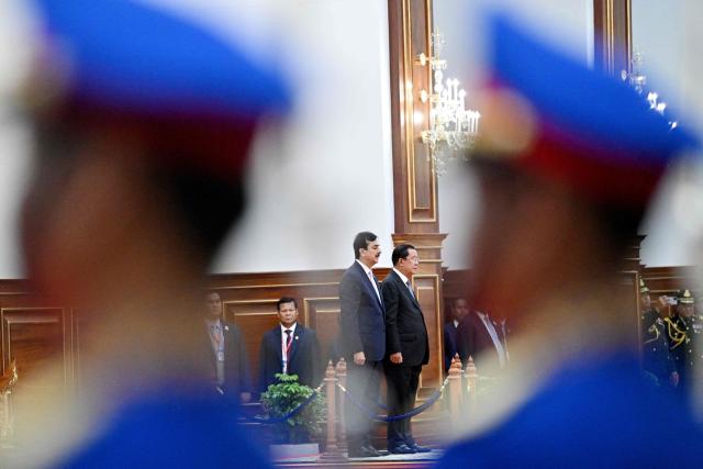 Cambodia's Senate President Hun Sen (centre R) and Pakistan's Senate Chairman Yusuf Raza Gilani (centre L) listen to their national anthems at the Senate building in Phnom Penh on February 2, 2026. (Photo by TANG CHHIN Sothy / AFP)