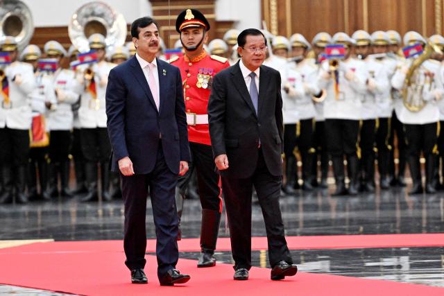 Cambodia's Senate President Hun Sen (R) and Pakistan's Senate Chairman Yusuf Raza Gilani (L) walk past an honour guard at the Senate building in Phnom Penh on February 2, 2026. (Photo by TANG CHHIN Sothy / AFP)