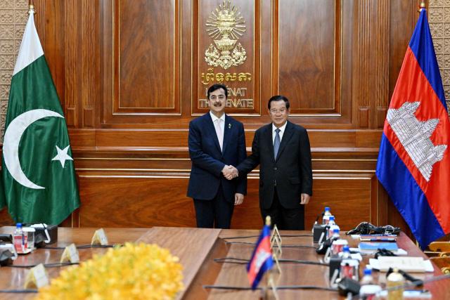 Cambodia's Senate President Hun Sen (R) shakes hands with Pakistan's Senate Chairman Yusuf Raza Gilani (L) at the Senate building in Phnom Penh on February 2, 2026. (Photo by TANG CHHIN Sothy / AFP)