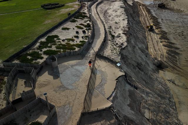 TOPSHOT - An aerial photograph shows damaged and collapsed sections of the Biscarrosse-Plage beachfront promenade in south-western France, on February 2, 2026. Approximately 50 meters of the beachfront concrete walkway and public benches collapsed into the Atlantic Ocean, leaving a gap along the Atlantic coast resort's beachfront infrastructure. (Photo by Philippe LOPEZ / AFP)