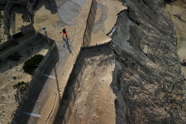 An aerial photograph shows damaged and collapsed sections of the Biscarrosse-Plage beachfront promenade in south-western France, on February 2, 2026. Approximately 50 meters of the beachfront concrete walkway and public benches collapsed into the Atlantic Ocean, leaving a gap along the Atlantic coast resort's beachfront infrastructure. (Photo by Philippe LOPEZ / AFP)