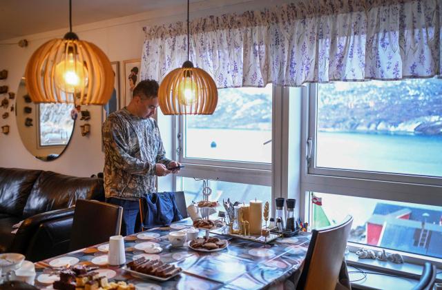 Hunter and fisherman Karl Joregn checks his mobile phone at the house of teacher Camilla Olsen at the settlement Sarfannguit, near Sisimiut, Greenland on February 1, 2026. Sarfannguit is a settlement in central-western Greenland, is located within the Aasivissuit  Nipisat UNESCO World Heritage Site, and was inscribed on the World Heritage List in 2018 for its outstanding archeological sites representing the human occupation of Greenland for over 4,000 years. Currently, approximately 50 residents live there.

Search for all these reportage images using: GREENLAND - DENMARK - HUNTING - SEALING. (Photo by Ina FASSBENDER / AFP)