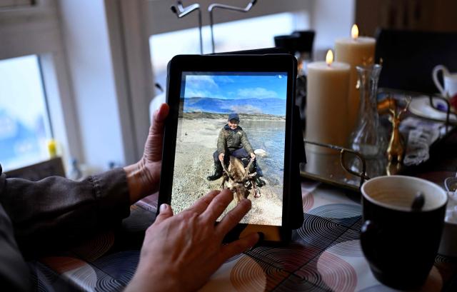 Teacher Camilla Olsen shows a photo on her iPad of her son shooting his first reindeer at her house at the settlement Sarfannguit, near Sisimiut, Greenland on February 1, 2026. Sarfannguit is a settlement in central-western Greenland, is located within the Aasivissuit  Nipisat UNESCO World Heritage Site, and was inscribed on the World Heritage List in 2018 for its outstanding archeological sites representing the human occupation of Greenland for over 4,000 years. Currently, approximately 50 residents live there.

Search for all these reportage images using: GREENLAND - DENMARK - HUNTING - SEALING. (Photo by Ina FASSBENDER / AFP)