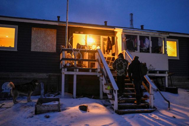 Hunter and fisherman Karl Joregn arrives with Malik Kleist after an unsuccessful hunt for seals at his home in Sisimiut, Greenland on February 1, 2026. Search for all these reportage images using: GREENLAND - DENMARK - HUNTING - SEALING. (Photo by Ina FASSBENDER / AFP)