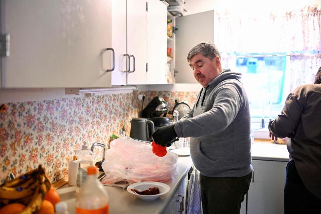 The husband of teacher Camilla Olsen opens a bag of seal meat at their home of the settlement Sarfannguit, near Sisimiut, Greenland on February 1, 2026. Sarfannguit is a settlement in central-western Greenland, is located within the Aasivissuit  Nipisat UNESCO World Heritage Site, and was inscribed on the World Heritage List in 2018 for its outstanding archeological sites representing the human occupation of Greenland for over 4,000 years. Currently, approximately 50 residents live there.

Search for all these reportage images using: GREENLAND - DENMARK - HUNTING - SEALING. (Photo by Ina FASSBENDER / AFP)
