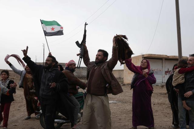 Residents cheer as members Syrian government internal security forces enter the northeastern Syrian city of Hasakeh on February 2, 2026. Damascus and Kurdish forces reached a comprehensive agreement on on January 30,2026, to gradually integrate the Kurds' military and civilian institutions into the state, after the minority ceded territory to advancing government forces in recent weeks. (Photo by Bakr ALkasem / AFP)