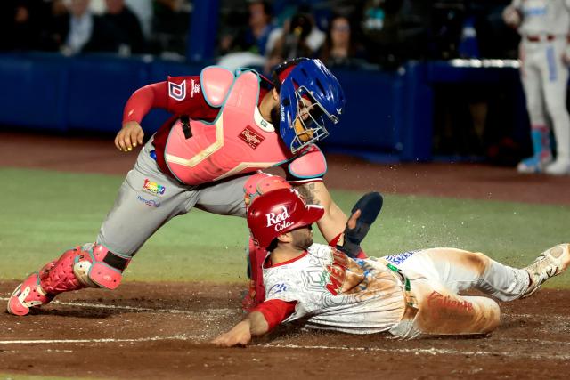Dominican Republic's #25 Michael de la Cruz (L) tags out Mexico's #26 Michael Wielansky during the Caribbean Series baseball tournament second game between Dominican Republic's Leones del Escogido and Mexico's Charros de Jalisco at the Panamerican Stadium in Jalisco, Mexico, on February 1, 2026. (Photo by Ulises Ruiz / AFP)