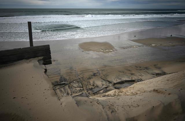 Broken concrete slabs lie scattered in the sand after the Biscarrosse-Plage seafront promenade collapsed, in south-western France, on February 1, 2026. Approximately 50 meters of the beachfront concrete walkway and public benches collapsed into the Atlantic Ocean, leaving a gap along the Atlantic coast resort's beachfront infrastructure. (Photo by Philippe LOPEZ / AFP)