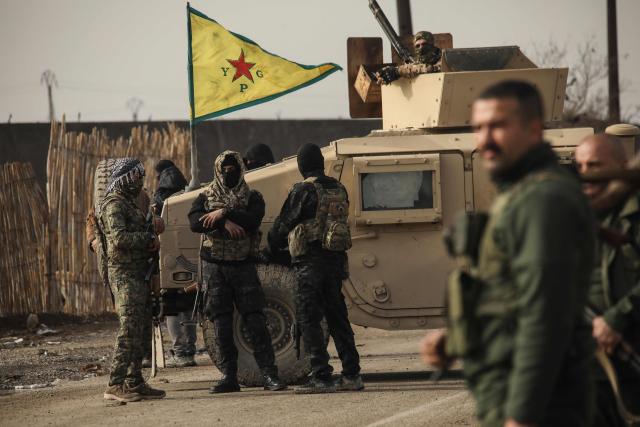 Kurdish forces stand guard as Syrian government internal security forces enter the northeastern Syrian city of Hasakeh on February 2, 2026. Syrian government security personnel on February 2, 2026, entered Hasakeh city, a stronghold of Kurdish forces, under an integration deal agreed with the Kurds last week, an AFP team reported. The two sides reached a comprehensive agreement on January 30 to gradually integrate the Kurds' military and civilian institutions into the state, after Kurdish forces ceded territory to advancing government troops in recent weeks after months of tensions and sporadic clashes. (Photo by Delil SOULEIMAN / AFP)