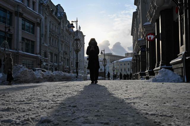 A woman walks along a street during a frosty day in central Moscow on February 2, 2026. (Photo by Hector RETAMAL / AFP)