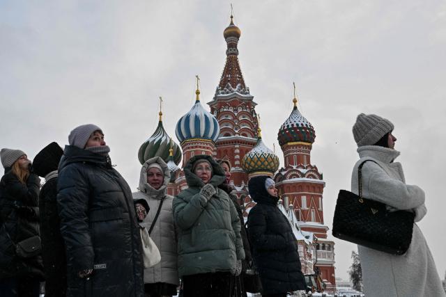 Tourists visit Red Square standing in front of St. Basil's Cathedral during a frosty day in central Moscow on February 2, 2026. (Photo by Hector RETAMAL / AFP)