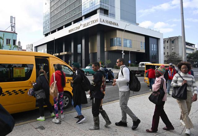 Cubans queue to board a public-transport minibus near the Iberostar Selection La Habana Hotel in Havana on February 2, 2026. Tourism in Cuba suffered a sharp setback in 2025. The country ended the year with 1.8 million visitors, a 17.8 percent drop from 2024 and far below the official target of 2.6 million, according to data published on February 1 by the National Office of Statistics and Information (ONEI), which described the period as "terrible" for one of the key sectors of the economy. (Photo by YAMIL LAGE / AFP)