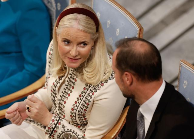 (FILES) Crown Princess Mette-Marit of Norway talks with Crown Prince Haakon of Norway (R) as they attend the Nobel Peace Prize award ceremony at the Oslo City Hall in Oslo, Norway on December 10, 2024. Norwegian Crown Princess Mette-Marit's life was once the stuff of fairytales, but rape charges against her son and her recently revealed friendship with convicted US sex offender Jeffrey Epstein have seen it rapidly turn into a nightmare. The tale of the single mother from humble beginnings, whose chance encounter with Crown Prince Haakon propelled her to the heart of the monarchy, won the affection of Norwegians. But her frequent exchanges with Epstein, published this weekend in Norwegian media, have exposed an unsuspected relationship that has shocked the Scandinavian country. (Photo by Odd ANDERSEN / AFP)