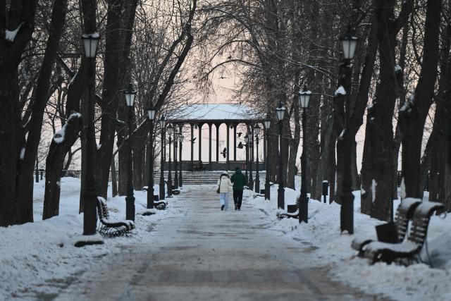 People walk on a cold winter day through a snow-covered park in central Kyiv on February 2, 2026, amid the Russian invasion of Ukraine. The Ukrainian Hydrometeorological Center reported that from February 1 to 3, nighttime temperatures in some regions of the country could drop to minus 27 °C. (Photo by Genya SAVILOV / AFP)