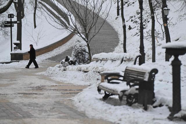 A woman walks on a cold winter day through a snow-covered park in central Kyiv on February 2, 2026, amid the Russian invasion of Ukraine. The Ukrainian Hydrometeorological Center reported that from February 1 to 3, nighttime temperatures in some regions of the country could drop to minus 27 °C. (Photo by Genya SAVILOV / AFP)