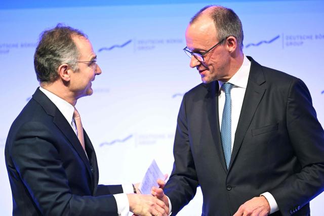 German Chancellor Friedrich Merz (R) after delivering a speech shakes hands with Chairman of the Executive Board of Deutsche Boerse Group, Austrian Stephan Leithner at the annual reception of the stock exchange operator Deutsche Boerse in Eschborn, western Germany, on February 2, 2026. (Photo by Kirill KUDRYAVTSEV / AFP)
