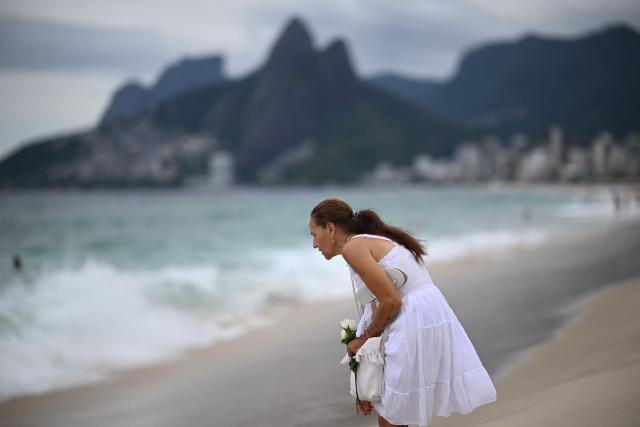 A worshipper takes part during the traditional ceremony of Iemanja, the Goddess of the Sea of the syncretic Afro-Brazilian religion Umbanda, at Arpoador Beach in Rio de Janeiro, Brazil, on February 2, 2026. (Photo by MAURO PIMENTEL / AFP)