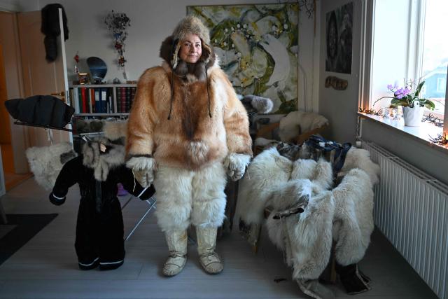 Musher Johanne Bech stands in the traditional clothing she wears when driving her sled dogs at her home in Sisimiut, Greenland on February 2, 2026. (Photo by Ina FASSBENDER / AFP)