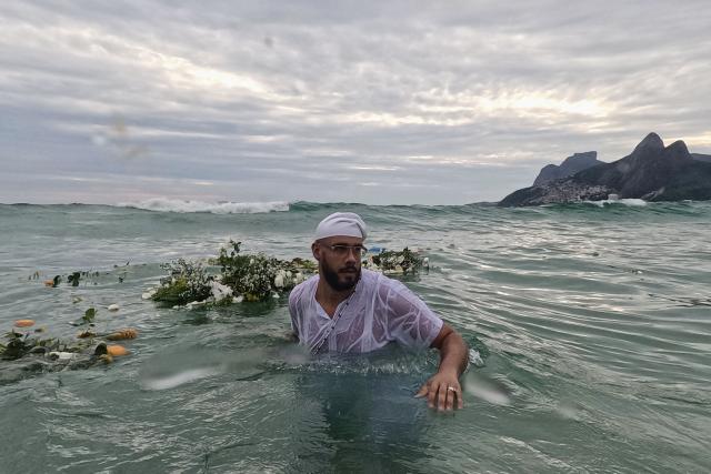 A worshipper takes part in the traditional ceremony of Iemanja, the Goddess of the Sea of the syncretic Afro-Brazilian religion Umbanda, at Arpoador Beach in Rio de Janeiro, Brazil, on February 2, 2026. (Photo by Mauro PIMENTEL / AFP)