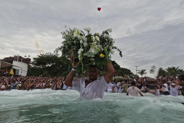 TOPSHOT - A worshipper takes part in the traditional ceremony of Iemanja, the Goddess of the Sea of the syncretic Afro-Brazilian religion Umbanda, at Arpoador Beach in Rio de Janeiro, Brazil, on February 2, 2026. (Photo by Mauro PIMENTEL / AFP)