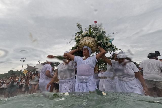 Worshippers take part in the traditional ceremony of Iemanja, the Goddess of the Sea of the syncretic Afro-Brazilian religion Umbanda, at Arpoador Beach in Rio de Janeiro, Brazil, on February 2, 2026. (Photo by Mauro PIMENTEL / AFP)