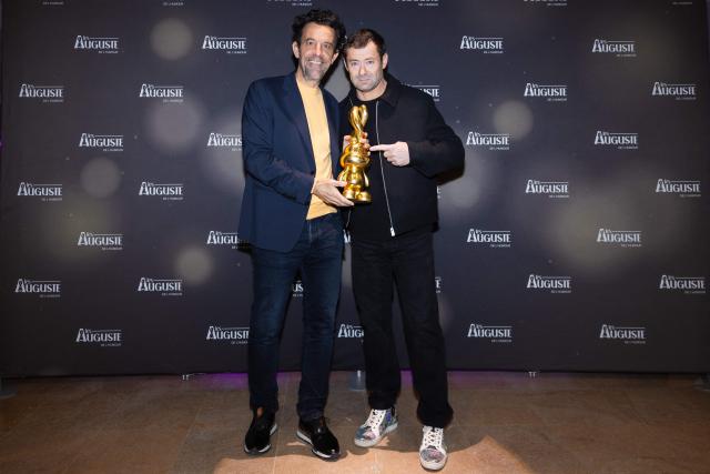 French artist and creator of the trophy, Auguste (R) and French Director of the Montreux Comedy Festival Gregoire Furrer (L) pose during the second edition of the Auguste de l'Humour awards ceremony for stand-up comedy and humorous performances at the "Nouveau Siecle" venue in Lille, northern France, on February 2, 2026. Elodie Poux was crowned comedian of the year at the second edition of the Auguste de l'humour awards in Lille on February 2, 2026, during a ceremony that sought to honour women after criticism of the overrepresentation of men among the nominees. (Photo by Sameer Al-DOUMY / AFP)
