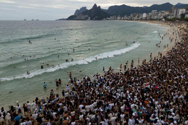 This aerial view shows worshippers taking part in the traditional ceremony of Iemanja, the Goddess of the Sea of the syncretic Afro-Brazilian religion Umbanda, at Arpoador Beach in Rio de Janeiro, Brazil, on February 2, 2026. (Photo by IVAN PISARENKO / AFP)