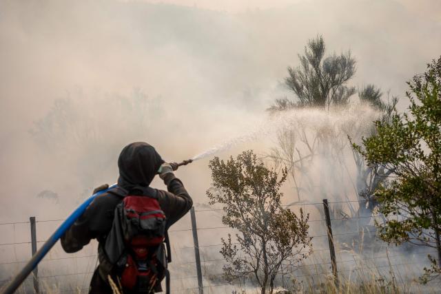 A firefighter works to extinguish a forest fire burning in the mountains of the rural area of Epuyen, in the Patagonian region of Chubut province, Argentina on February 2, 2026. Argentina's government on January 29, 2026, declared an emergency in Patagonia, where wildfires have ripped through vast tracts of forest since the start of the Southern Hemisphere summer. (Photo by TOMAS CUESTA / AFP)