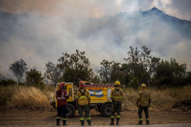 Firefighters look on as a forest fire burns in the mountains of the rural area of Epuyén, in the Patagonian region of Chubut province, Argentina on February 2, 2026. Argentina's government on January 29, 2026, declared an emergency in Patagonia, where wildfires have ripped through vast tracts of forest since the start of the Southern Hemisphere summer. (Photo by TOMAS CUESTA / AFP)