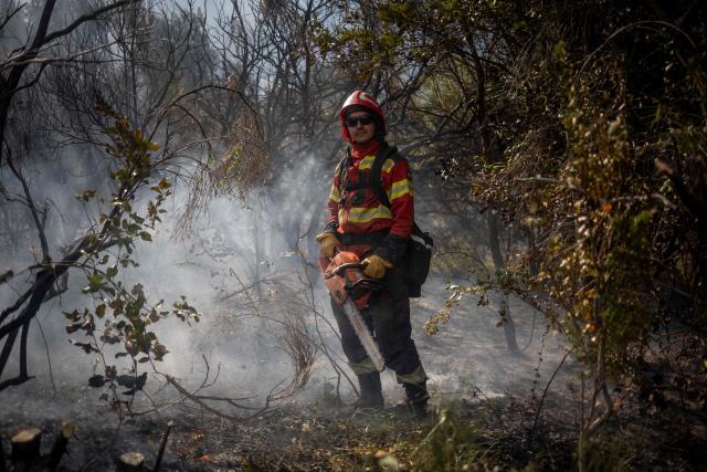 A firefighter works to extinguish a forest fire burning in the mountains of the rural area of Epuyen, in the Patagonian region of Chubut province, Argentina on February 2, 2026. Argentina's government on January 29, 2026, declared an emergency in Patagonia, where wildfires have ripped through vast tracts of forest since the start of the Southern Hemisphere summer. (Photo by TOMAS CUESTA / AFP)