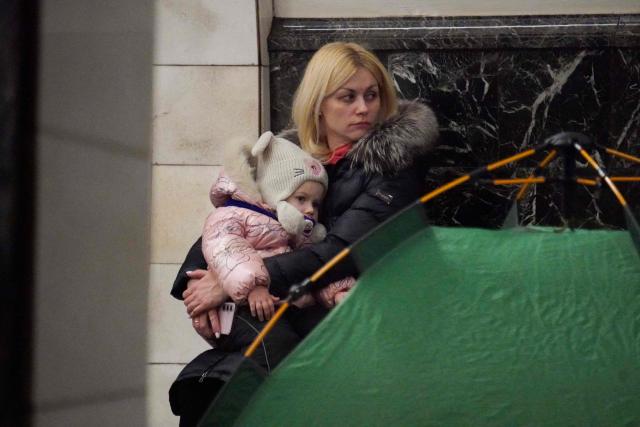 A woman holds a child as people take shelter at a metro station during a Russian air attack, in Kyiv, on early February 3, 2026, amid the Russian invasion of Ukraine. (Photo by Serhii Okunev / AFP)