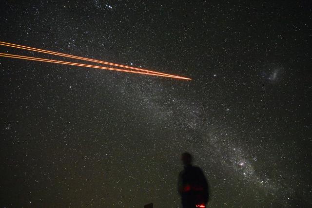 (FILES) Picture of the powerful lasers emerging from the new laser system on Unit Telescope 4 of ESO’s Very Large Telescope at ESO’s Paranal Observatory on Paranal Hill in Chile's Antofagasta Region, in the Atacama Desert some 1150 km north of Santiago, on January 27, 2025. Europe's ESO star-gazing organisation on February 2, 2026 welcomed plans to call off building a massive green energy project in the Chilean desert which threatened to spoil its telescopes' view of the darkest skies on Earth. (Photo by RODRIGO ARANGUA / AFP)