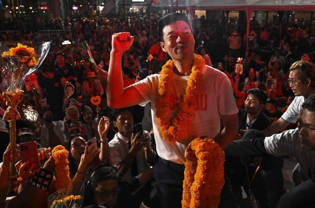 (FILES) People's Party leader and prime ministerial candidate Natthaphong Ruengpanyawut (C) gestures during a campaign rally ahead of the general election in Bangkok on January 25, 2026. Thousands of young orange-clad supporters cheered the rallies of Thailand's most popular political party ahead of elections on February 8, but few expect it to take power. While the People's Party is far ahead in the polls, promising to tackle corruption and reform Thailand's strict royal insult laws, even some of the party's lawmakers have their doubts. (Photo by Lillian SUWANRUMPHA / AFP)