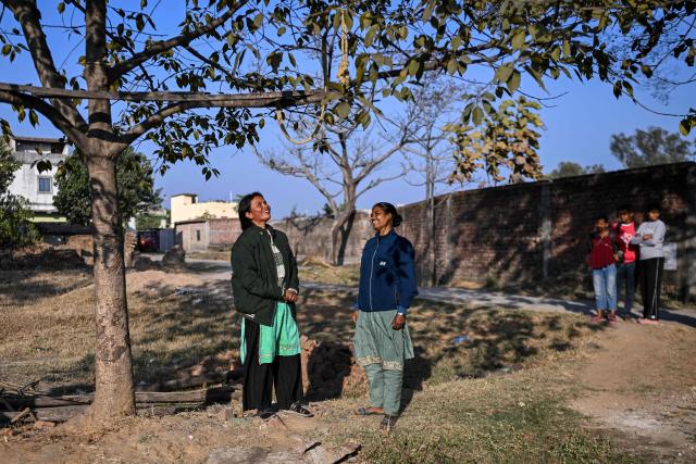 This photograph taken on January 16, 2026 shows AI data labellers Anju Kamari (L) and Chandmani Kerketta interacting with each other in Messa village on the outskirts of Ranchi in India's Jharkhand state. India, which will host an international AI summit this month, has ambitious plans. Cities such as Bengaluru, Hyderabad and Chennai host major international players, but India's AI push is also expanding into more remote regions. As AI reaches rural India, it is quietly reshaping lives -- particularly for women from conservative backgrounds. (Photo by Arun SANKAR / AFP) / To go with 'India-AI-Employment-Women', FOCUS