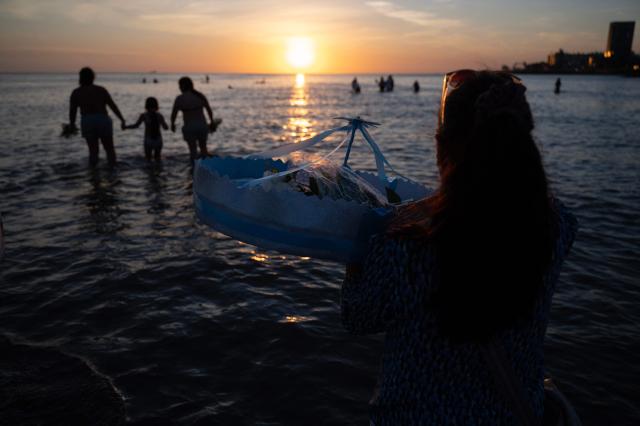 Believers offer tribute to Iemanja, the Goddess of the Sea of the Afro-American religion Umbanda, at Ramirez Beach in Montevideo on February 2, 2026. (Photo by Eitan ABRAMOVICH / AFP)