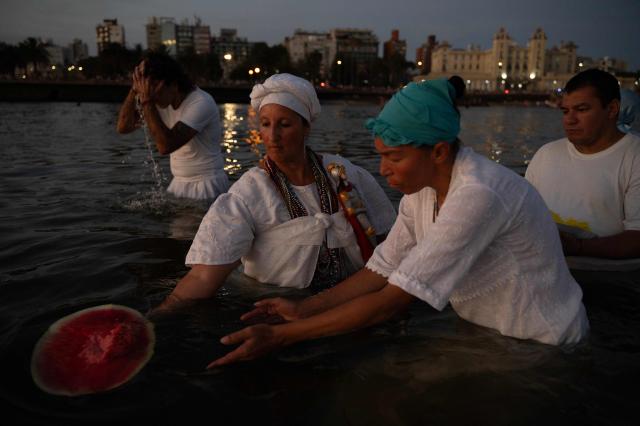 Believers offer tribute to Iemanja, the Goddess of the Sea of the Afro-American religion Umbanda, at Ramirez Beach in Montevideo on February 2, 2026. (Photo by Eitan ABRAMOVICH / AFP)