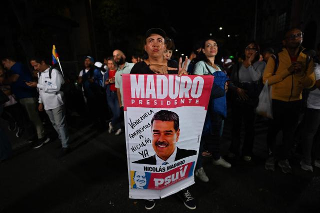 A supporter of ousted President Nicolas Maduro gestures as she takes part in a vigil in Caracas on February 2, 2026. On February 2 Washington's new top diplomat in Venezuela said that in a meeting with the country's interim president she addressed the issue of a transition after the ouster of Nicolas Maduro. (Photo by Juan BARRETO / AFP)