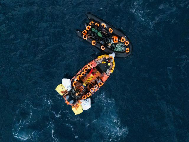 (FILES) This aerial photograph shows crew members of the “Ocean Viking” rescue ship rescueing a boat carrying migrants in destress using a RHIB (Rigid inflatable boat) in the search-and-rescue zone off the international waters of Libya on January 16, 2026. Nearly six months after coming under fire off the coast of Libya, the "Ocean Viking", an ambulance ship chartered by SOS Mediterranee, has returned to sea for the first time in recent weeks, rescuing more than 120 migrants in a sometimes tense context. (Photo by Sameer Al-DOUMY / AFP)