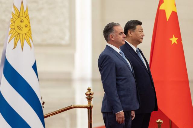 Uruguay's President Yamandu Orsi (L) stands with Chinese President Xi Jinping during a welcome ceremony in Beijing on February 3, 2026. (Photo by JESSICA LEE / POOL / AFP)