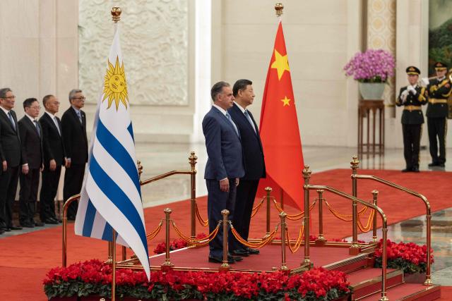 Uruguay's President Yamandu Orsi (L) stands with Chinese President Xi Jinping during a welcome ceremony at the Great Hall of the People in Beijing on February 3, 2026. (Photo by JESSICA LEE / POOL / AFP)