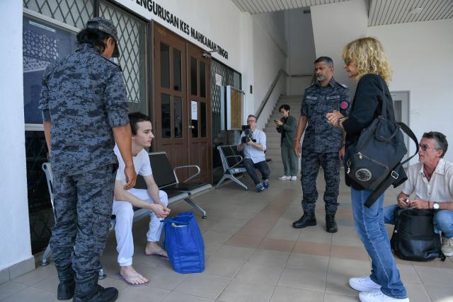 French national Tom Felix (2nd L) sits next to Malaysian immigration officers as his parents Jean Luc Felix (R) and Sylvie Felix (2nd R) look on after he was acquitted on eight drug-related charges at the High Court in Alor Setar on February 3, 2026. A Malaysian court acquitted on February 3 a French national facing the death penalty of eight drug-related charges, freeing him after nearly two and a half years in detention. (Photo by Hakim Mustapha / AFP)