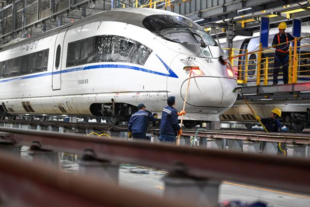 Workers clean a high speed train at the Xuzhou East high-speed train depot in Xuzhou, in China’s eastern Jiangsu province on February 3, 2026. China’s annual Chunyun Spring Festival travel period began on February 2, in the buildup to the Lunar New Year of the Horse which falls on February 17. (Photo by AFP) / China OUT