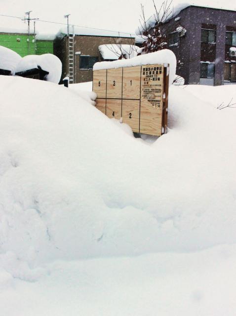 This photo taken on January 24, 2026 shows a board, used for displaying posters of candidates in the House of Representatives election, buried in heavy snow in Aomori City. Unusually heavy snow is wreaking havoc in Japan, causing 30 deaths in the past two weeks as the central government deployed troops to help clear roads and homes, officials said on February 3. (Photo by JIJI Press / AFP) / Japan OUT