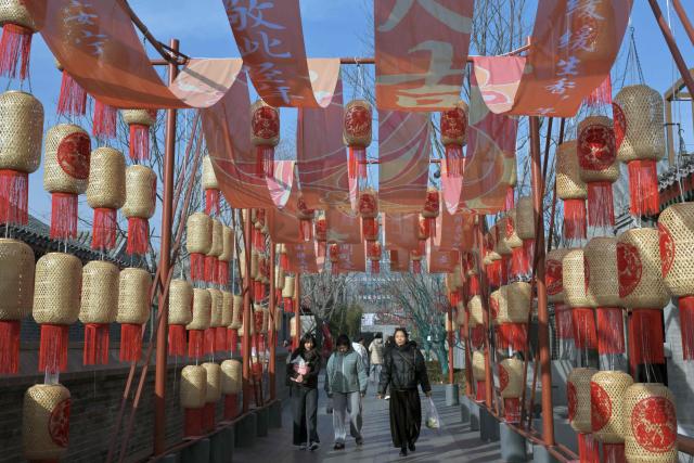 People walk past decorative lanterns at the Zhonghai Daji Alley shopping centre in Beijing on February 3, 2026. (Photo by ADEK BERRY / AFP)