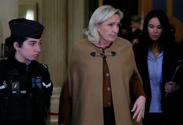 President of the parliamentary group of the French far-right Rassemblement National (RN) party, Marine Le Pen (C) leaves after a break during her appeal trial on charges of embezzlement of European public funds in a case of alleged European Parliament fake jobs at the Palais de Justice in Paris on February 3, 2026. Le Pen is called to the stand in the appeal trial in Paris of the parliamentary assistants of the National Front, where she is playing for her candidacy for the 2027 presidential election. Twelve of the accused, as well as the far-right party itself, have appealed against the verdict while another 12 people -- including one of Le Pen's sisters -- have decided to accept their convictions without appealing. The public prosecutor's office is expected to announce its charges against Marine Le Pen, the National Rally party, and ten party officials on February 3, 2026. (Photo by Thomas SAMSON / AFP)