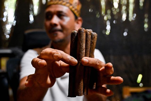 A cigar maker shows his homemade cigars in Montasik, Aceh province on February 3, 2026. (Photo by CHAIDEER MAHYUDDIN / AFP)